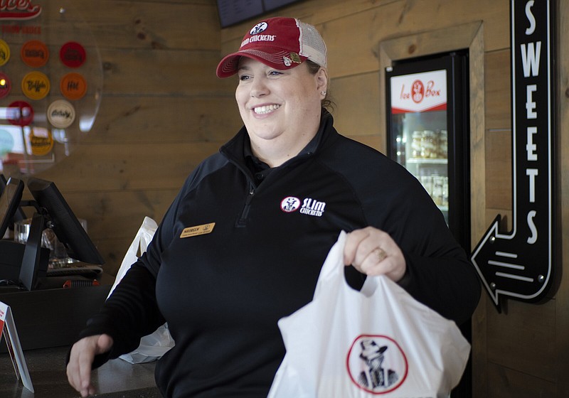 General Manager Maureen McCarthy walks an order out to a table, Thursday, January 26, 2023 at Slim Chickens in Bentonville. Visit nwaonline.com/photos for today's photo gallery.

(NWA Democrat-Gazette/Charlie Kaijo)