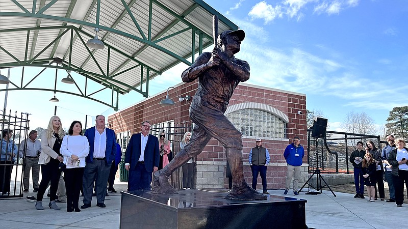 Dr. Robert Muldoon, right, and members of the Daniel Hamby family look at the recently unveiled statue of Babe Ruth at Majestic Park Monday. - Photo by James Leigh of The Sentinel-Record
