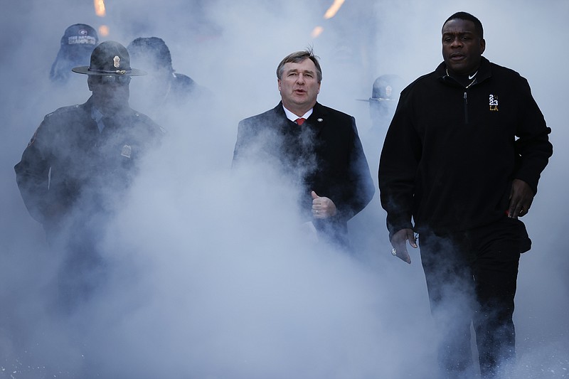 FILE - Georgia head coach Kirby Smart, center, enters the stadium during a ceremony celebrating the Bulldog's second consecutive NCAA college football national championship on Jan. 14, 2023, in Athens, Ga. The first Wednesday of February used to be the biggest day on the calendar for college football recruiting. Now it’s an afterthought. Before the championship game, Smart and TCU’s Sonny Dykes both called for changes to the crowded college football calendar without going into specifics. (AP Photo/Alex Slitz, File)