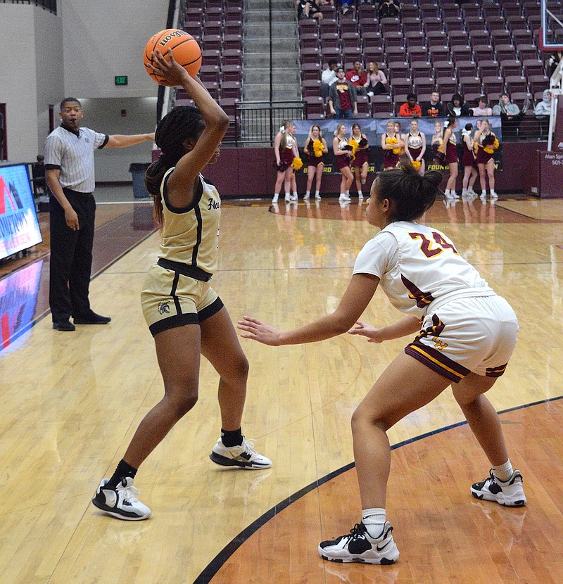 Hot Springs' Kyabra Lomax looks for a pass while Lake Hamilton's Paris Macon (24) guards Friday at Wolf Arena. - Photo by Donald Cross of The Sentinel-Record