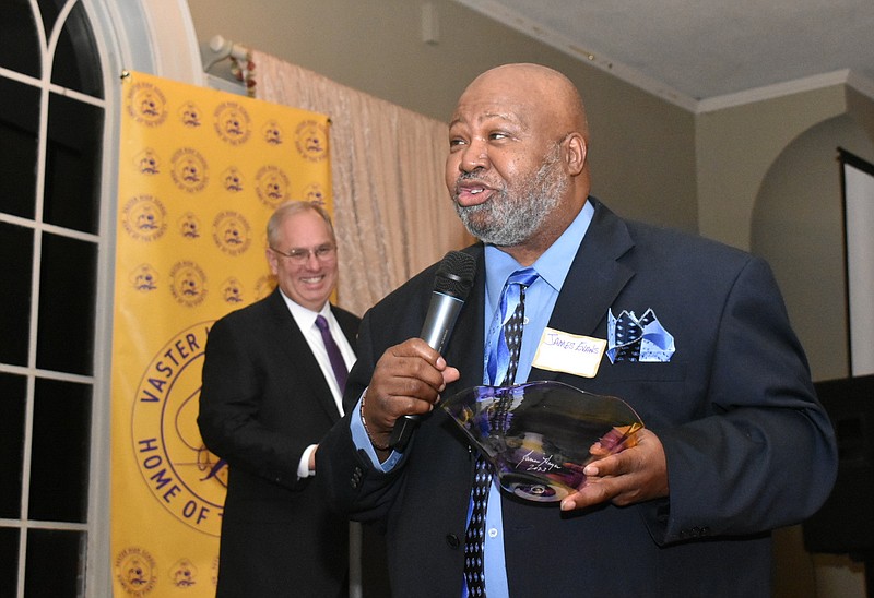 James Evans, a member the 1973 Class B state champion Vaster High School boys basketball team, makes remarks to keynote speaker Sidney Moncrief (off camera) as emcee and dinner organizer David Beck laughs Friday at the Pine Bluff Country Center. (Pine Bluff Commercial/I.C. Murrell)