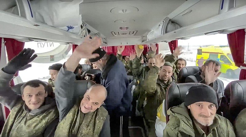 In this handout photo taken from video released by Russian Defense Ministry Press Service on Saturday, Feb. 4, 2023, a group of Russian soldiers wave at a cameraman sitting in a bus after being released in a prisoners swap between Russia and Ukraine somewhere at an unspecified location in Belgorod region in Russia.(Russian Defense Ministry Press Service via AP)