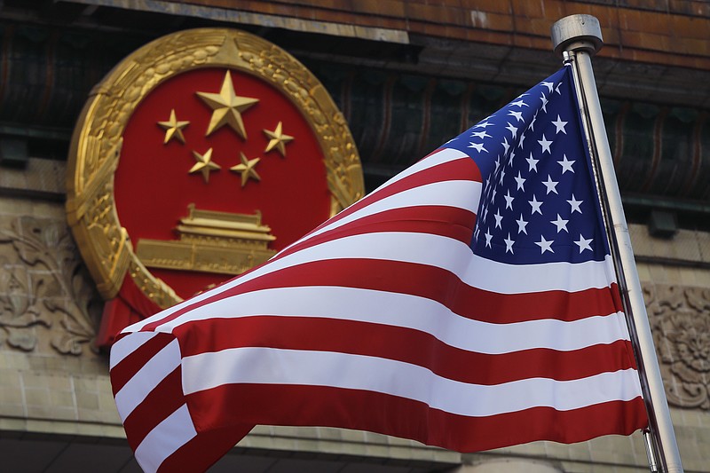 FILE - An American flag is flown next to the Chinese national emblem during a welcome ceremony at the Great Hall of the People in Beijing, Nov. 9, 2017. Secretary of State Antony Blinken has postponed  a planned high-stakes weekend diplomatic trip to China as the Biden administration weighs a broader response to the discovery of a high-altitude Chinese balloon flying over sensitive sites in the western United States, a U.S. official said Friday.(AP Photo/Andy Wong, File)