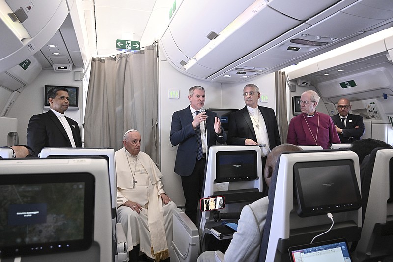 The Archbishop of Canterbury Justin Welby, right, Pope Francis, left, and the Moderator of the General Assembly of the Church of Scotland Iain Greenshields meet the journalists during an airborne press conference Sunday, Feb. 5, 2023, aboard an airplane bound for Rome at the end of Francis' pastoral visit to Congo and South Sudan. (Tiziana Fabi/Pool Photo Via AP)