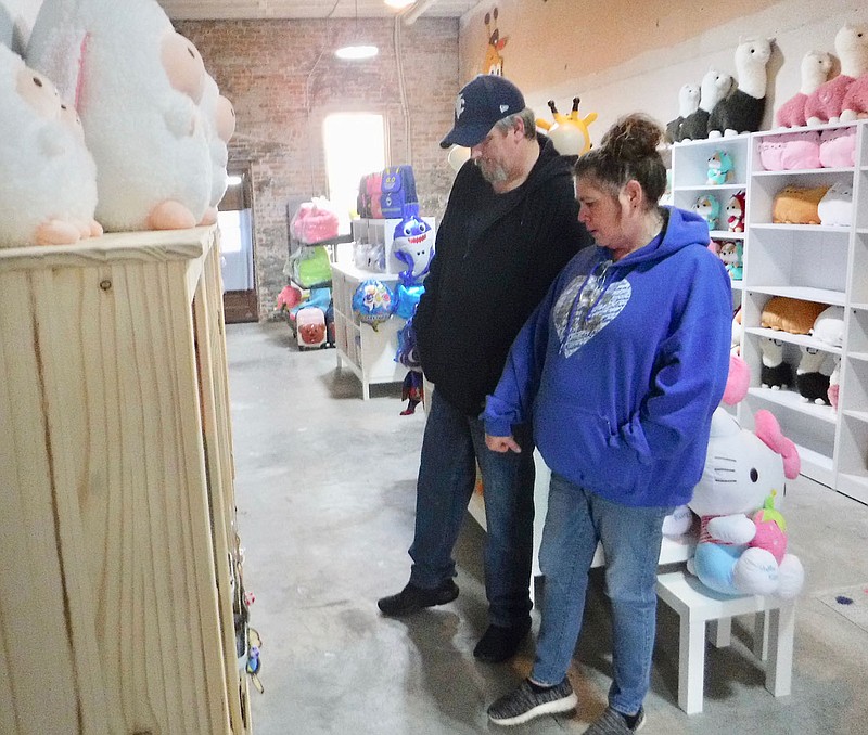 Susan Holland/Westside Eagle Observer
Phillip and Shannon Knapp, of Gravette, browse in Mei Mei's, the new children's store recently opened in the back of the Lili's Bubble Waffles shop. The Knapps found several items they thought would interest youngsters they knew. Their son, Jaden Knapp, a student at Arkansas Connections Academy, is one of the employees of the store