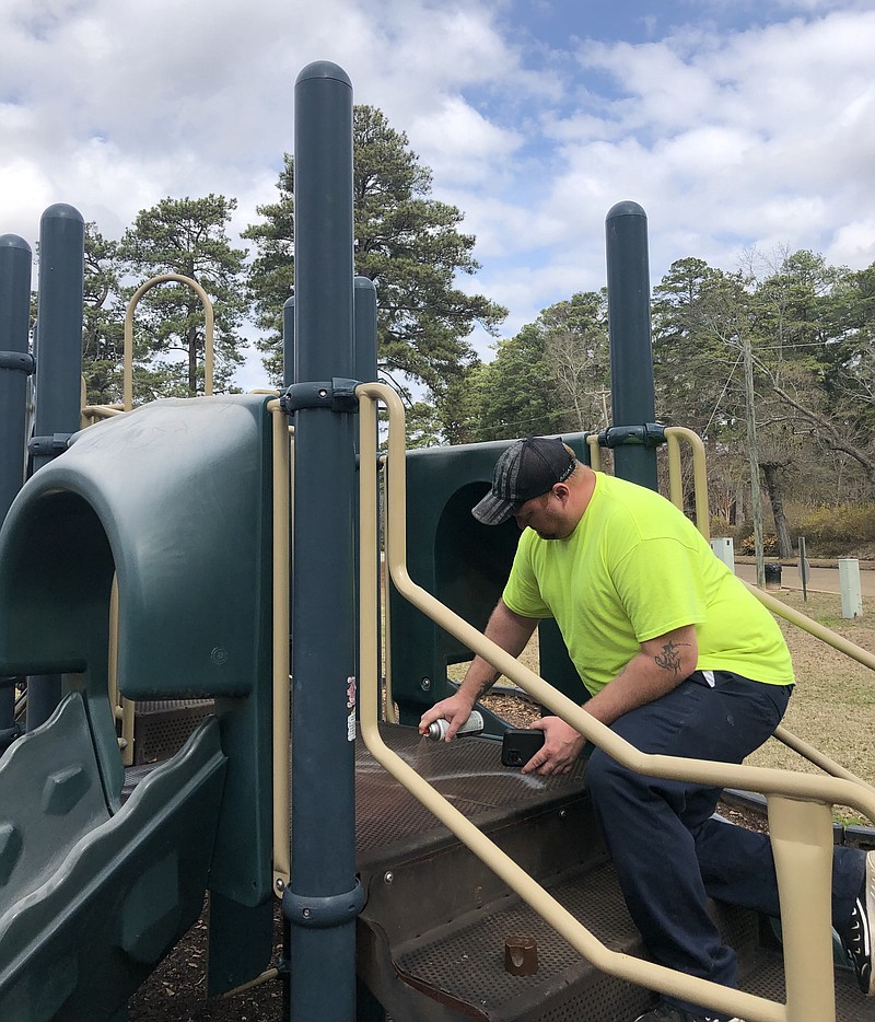 Michael Lewis, city parks and green space manager, scrubs and paints over graffiti on a piece of playground equipment in Mellor Park. Anti-Semitic graffiti was reported in the park last month. City crews cleaned the offensive messages from the Mellor Park pavilion in January. A member of the El Dorado Parks and Playgrounds Commission discovered more anti-Semitic graffiti atop a slide on Monday. (Contributed)