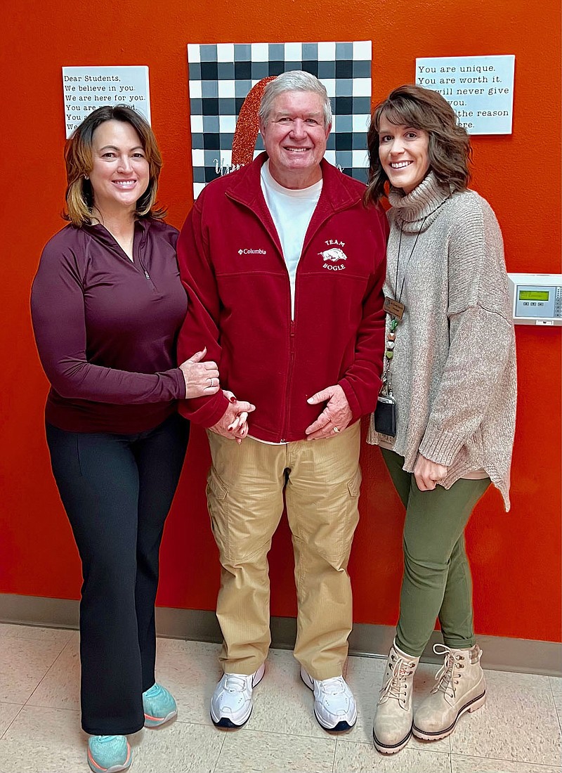 Submitted photo Bob and Tina Bogle, of Bentonville, pose with Mandy Barrett (right), principal at Glenn Duffy Elementary School, after making a donation to wipe out all student lunch debt at Glenn Duffy Elementary and Gravette Upper Elementary schools. Bogle and his wife visited the school early Monday morning, Feb. 6, and wrote a check for $7,246.10, zeroing out all balances on the school lunch accounts. “They were the kindest, most thoughtful couple,” Barrett commented.