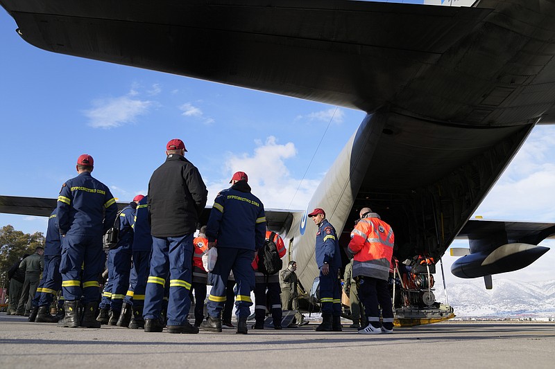 Greek firefighters wait to enter a military plane at Elefsina Air Force Base, in western Athens, Greece, Monday, Feb. 6, 2023. Greece announced it is sending a team of 21 rescuers, two rescue dogs and a special rescue vehicle, together with a structural engineer, five doctors and seismic planning experts, all traveling in a military transport plane, after a 7.8 magnitude earthquake centered in Turkey. (AP Photo/Thanassis Stavrakis)
