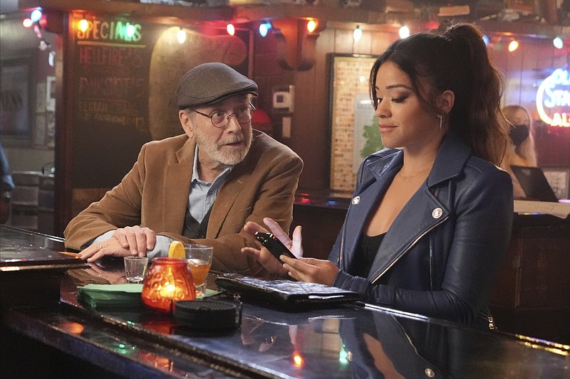 Martin Mull (left) and Gina Rodriguez are shown at a bar in a scene from ABC’s “Not Dead Yet.” (ABC via AP/Eric McCandless)