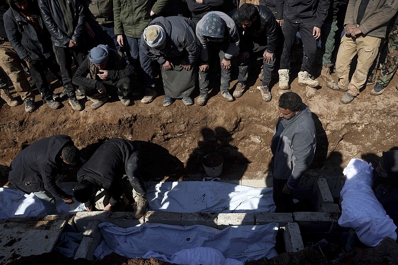 Mourners bury family members who died in a devastating earthquake that rocked Syria and Turkey at a cemetery in the town of Jinderis, Aleppo province, Syria, Tuesday, Feb. 7, 2023.  A newborn girl was found buried under debris with her umbilical cord still connected to her mother, Afraa Abu Hadiya, who was found dead, according to relatives and a doctor.  The baby was the only member of her family to survive from the building collapse Monday in  Jinderis, next to the Turkish border, Ramadan Sleiman, a relative, told The Associated Press. (AP Photo/Ghaith Alsayed)