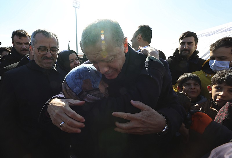 Turkey's President Recep Tayyip Erdogan and a survivor hug each other as he visits the city center destroyed by Monday earthquake in Kahramanmaras, southern Turkey, Wednesday, Feb. 8, 2023. Thinly stretched rescue teams worked through the night in Turkey and Syria, pulling more bodies from the rubble of thousands of buildings toppled by a catastrophic earthquake. The death toll rose Wednesday, making the quake the deadliest in more than a decade. (Turkish Presidency via AP )