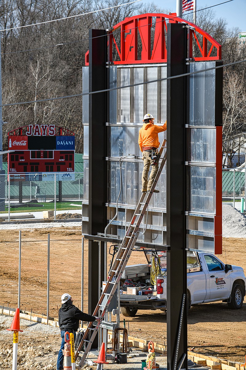 Julie Smith/News Tribune
Steady progress is being made at the new athletic complex at Jefferson City High School. Shown here Tuesday are electricians Mike Buschjost, on ladder, and Alex Drinkard of Meyer Electric who were running electricity to the upper scoreboard for the softball and baseball field.