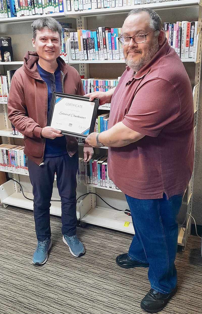 Submitted photo Braxton Sawyer, a member of the Gravette Public Library advisory board, presents a certificate of appreciation to outgoing member Edward Couchenour (left). Couchenour was honored for his four years of service on the board.