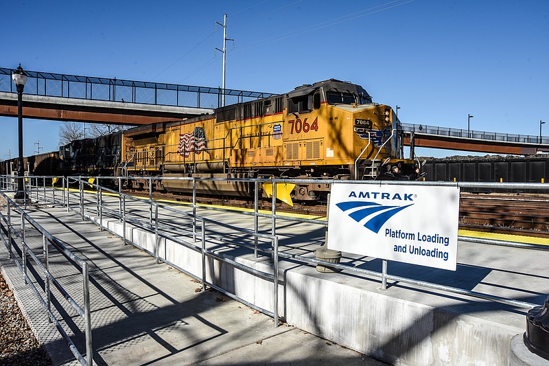 Julie Smith/News Tribune
 A Union Pacific freight train is shown Monday as it passes by the new Amtrak passenger platform at the foot of Jefferson Street.  A crew is working just to the east of this section on the next portion that when completed, will provide a 325-foot long concrete, boarding and unboarding area. The new platform includes a handicap ramp and secure railing. The platform is being constructed with appropriations received through the federal government to bring it in compliance with ADA requirements.