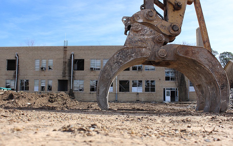 The hydraulic claw of a Hart Construction excavator rests on the ground at the former Pine Street campus during demolition Monday, Feb. 13, 2023, in Texarkana, Texas. Texarkana Independent School District repurchased the property from Dallas-based Old School Lofts Joint Ventures in summer 2022 for $585,000. In the November 2022 election, district voters approved a $189 million bond that includes money to raze the buildings on the historic campus and construct a school to replace Highland Park and Spring Lake Park elementary schools. Asbestos abatement by Gill Industries Ltd. of Louisiana is ongoing. (Staff photo by Stevon Gamble)