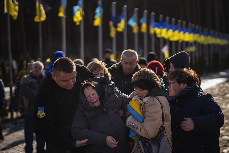 Valentyna Samoilenko reacts next to the body of her son Dmytro, 34, during his funeral in Irpin, near Kyiv, Ukraine, Tuesday, Feb. 14, 2023. Dmytro Samoilenko, a civilian who was a volunteer in the armed forces of Ukraine, was killed in the fighting in Bakhmut area. (AP Photo/Emilio Morenatti)