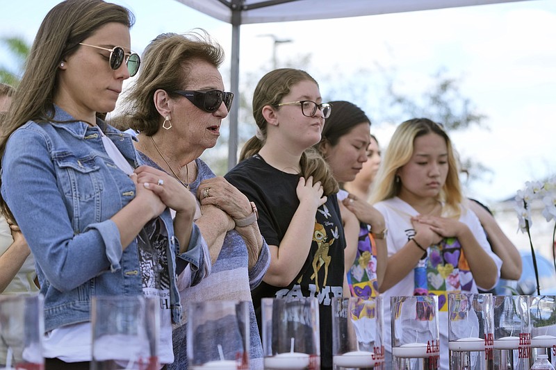 Family members of the Parkland, Fla., shooting victims prepare to light candles in their names, Tuesday, Feb. 14, 2023, at a ceremony in Coral Springs, Fla., honoring the lives of the 17 students and staff of Marjory Stoneman Douglas High School that were killed on Valentine's Day in 2018. (AP Photo/Wilfredo Lee)