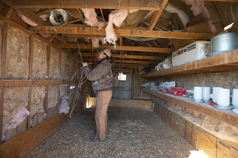 Farm manager Nena Hammer cleans out a chicken brooder house Friday Feb. 17, 2023 at Cobblestone Farm in Fayetteville. Construction has begun on the Cobblestone Farm Community near the farm. The community aims to provide affordable housing to low-income families in a diverse, inclusive environment with additional services and resources that will help them thrive.   Visit nwaonline.com/photo for today's photo gallery.   (NWA Democrat-Gazette/J.T. Wampler)