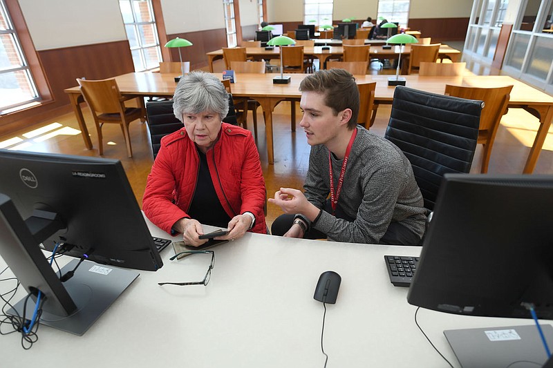 Library patron Paula Furlough gets some computer help Friday, Feb. 17, 2023, from library worker Nathan Harkey a computer room at the Fayetteville Public Library. The Ivy Group, a consultant based in Charlottesville, Va., did a community needs assessment for as a way to help guide the libraryÃ•s future operations. Visit nwaonline.com/photo for today's photo gallery. 
(NWA Democrat-Gazette/Andy Shupe)