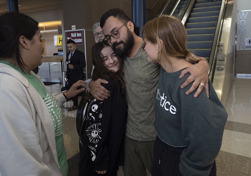 Cesar Acosta (center) hugs Michelle Breslin (left) and his wife Megan Taylor on Wednesday at Northwest Arkansas National Airport in Bentonville. Acosta, a newlywed from Springdale returning from his wedding in Mexico, was released after being detained by federal immigration authorities on Feb. 13. Visit nwaonline.com/photos for today’s photo gallery.

(NWA Democrat-Gazette/Charlie Kaijo)