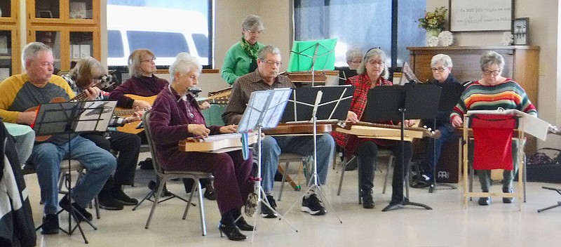 Susan Holland/Westside Eagle Observer Members of Southern Strings, a group of musicians from Bella Vista who play traditional Southern stringed instruments, entertain at the Billy V. Hall Senior Activity Center Thursday afternoon, Feb. 23. The group is composed of 14 members. The 10 who came to Gravette are Sande Sederburg (front row, left), dulcimer and harmonica; Mark Kirby and Rosie Floyd, dulcimers; Donna Slayton, dulcimer and spoons; Rick Uttley (back row), ukelele; Linda Uttley and Pam Meyer, guitars; Lisa Ferguson, hammered dulcimer; Jane Spunaugle, violin; and Pat Kirby, cajon, folk harp and psaltery.