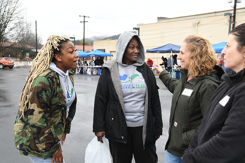 I'Nita White talks with her fellow volunteers at The Giving Team Inc.'s Food For Thought Saturday. - Photo by Lance Brownfield of The Sentinel-Record