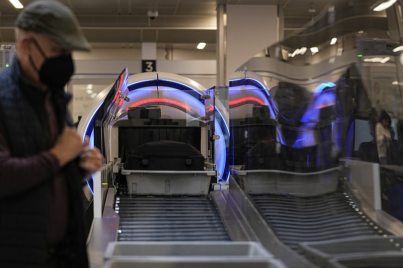 People wait for their belongings at the Transportation Security Administration security area at the Hartsfield-Jackson Atlanta International Airport on Wednesday, Jan. 25, 2023, in Atlanta. (AP Photo/Brynn Anderson)