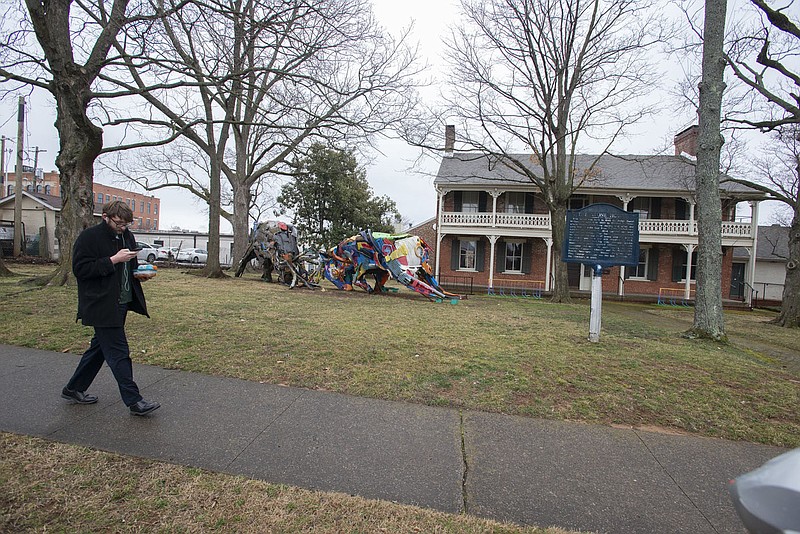 Hayden Strahan of Farmington walks Feb. 7 past a sculpture on the lawn of the historic Walker-Stone House in Fayetteville. The city’s Advertising and Promotion Commission on Monday approved a lease agreement for the space with Folk School of Fayetteville, the nonprofit behind Fayetteville Roots.

(File photo/NWA Democrat-Gazette/J.T. Wampler)