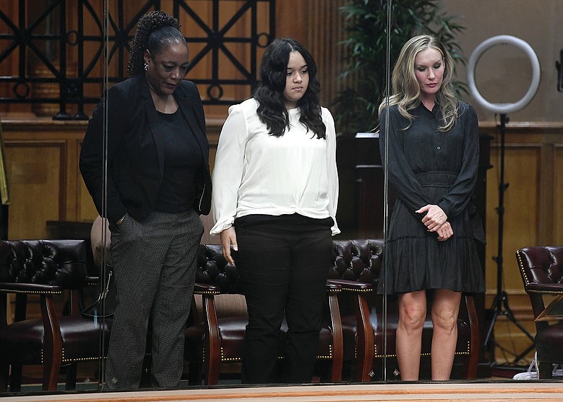 (From left) Jacquelyn Parks, Vivianna "Vivi" Parks, and Christina Parks, Mother, daughter, and wife of Cadet Vincent Parks, stand in the North Gallery of the Arkansas House of Representatives during presentation of HB1458, about training at Law Enforcement academy, during a meeting of the House on Monday, Feb. 27, 2023. Parks died during a training session in extreme heat last July.

(Arkansas Democrat-Gazette/Stephen Swofford)