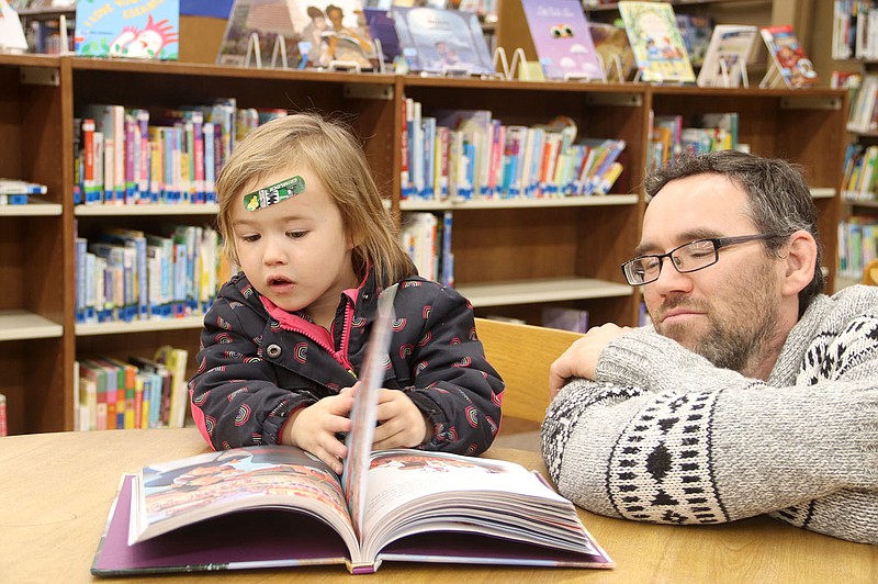 Lynn Kutter/Enterprise-Leader
Jordan Cassadee and his son, Crawford, 3, of Prairie Grove look at a book waiting for story time to start this day at Prairie Grove Public Library. Storytime is held 10 a.m. Wednesdays.
