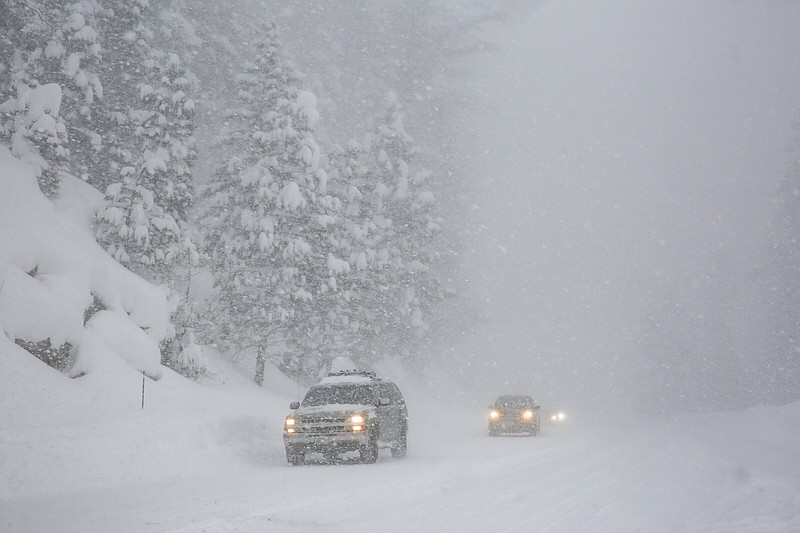 Vehicles travel in snowy conditions along eastbound Highway 50 between Kyburz and Strawberry, Calif., on Tuesday, Feb. 28, 2023. (Salgu Wissmath/San Francisco Chronicle via AP)