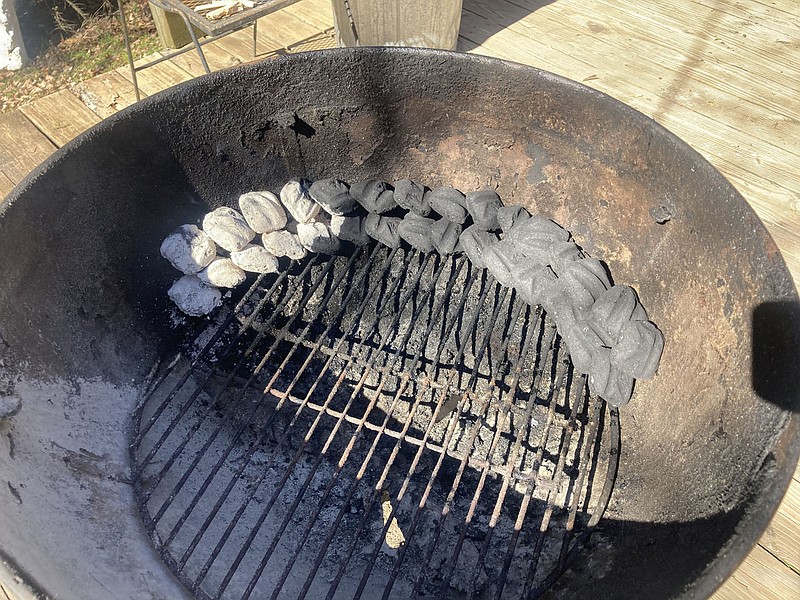 Lining up two rows of charcoal briquettes and lighting one end makes for a low temperature inside a covered grill that lasts for hours. It's ideal for making jerky.
(NWA Democrat-Gazette/Flip Putthoff)