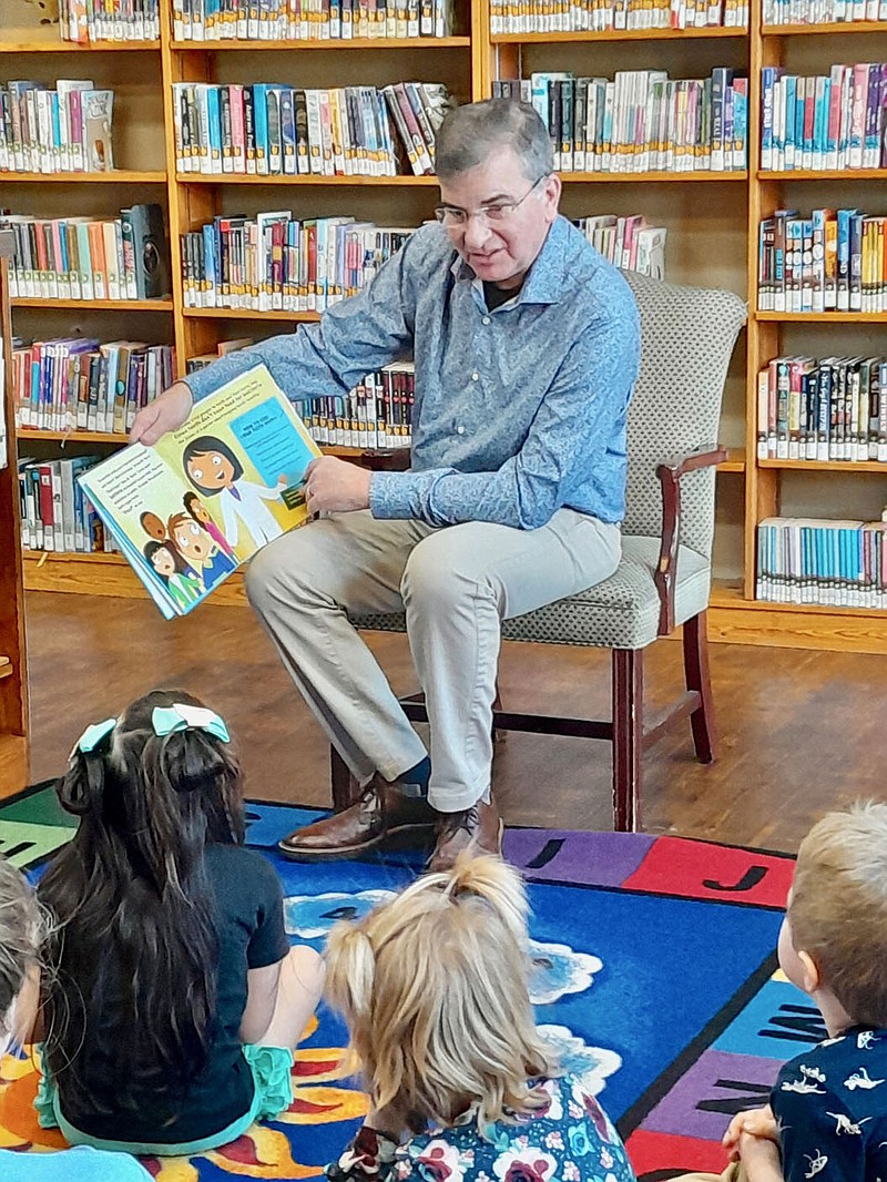 Submitted Photo
Dr. Kent Leonard, Gravette dentist, reads "Let's Meet a Dentist" to children at the Gravette Public Library Tuesday, Feb. 28. Dr. Leonard's visit to the library was in recognition of February as National Children's Dental Health Month. The American Dental Association sponsors the month each year to raise awareness of the importance of oral health. This year's theme was Brush, Floss, Smile!