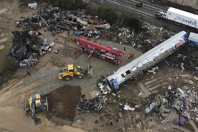 The wreckage of the trains lie next to the rail lines, after Tuesday's rail crash, the country's deadliest on record, in Tempe, about 376 kilometres (235 miles) north of Athens, near Larissa city, Greece, Friday, March 3, 2023. Greece has a limited rail network that doesn't reach much of the country. Despite years of modernization projects, much of the key rail control work is still manually operated. (AP Photo/Giannis Papanikos)
