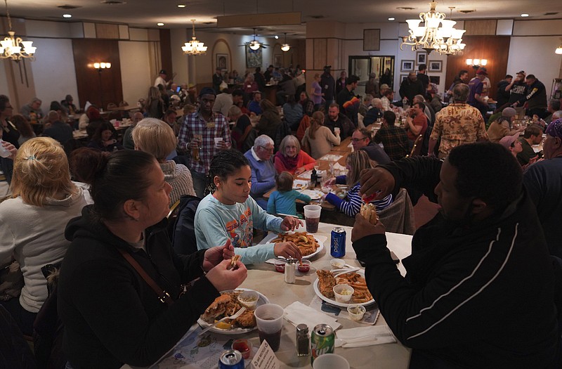 Valerie Mozes, left, Seveyah Mozes, 9, center, and John Oliver, eat a fish dinner on the first night of Lent at the Allegheny Elks Lodge #339 in Pittsburgh, on Friday, Feb. 24, 2023. Fish fries have been a longtime Catholic tradition in Western Pennsylvania but increased in popularity in 1966 after the Second Vatican Council announced that not eating meat on Fridays was optional, except during Lent. Today they are held anywhere, from churches to fire stations to restaurants. (AP Photo/Jessie Wardarski)