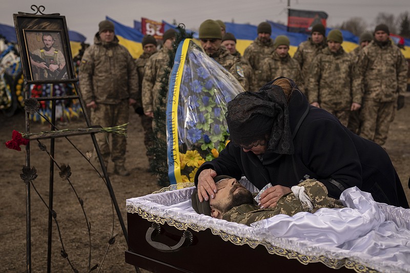 Tetiana Hurieieva, the mother of Volodymyr Hurieiev, a Ukrainian soldier killed in the Bakhmut area, cries during the funeral in Boryspil, Ukraine, Saturday, March 4, 2023. Pressure from Russian forces mounted Saturday on Ukrainians hunkered down in Bakhmut, as residents attempted to flee with help from troops who Western analysts say may be preparing to withdraw from the key eastern stronghold. (AP Photo/Vadim Ghirda)