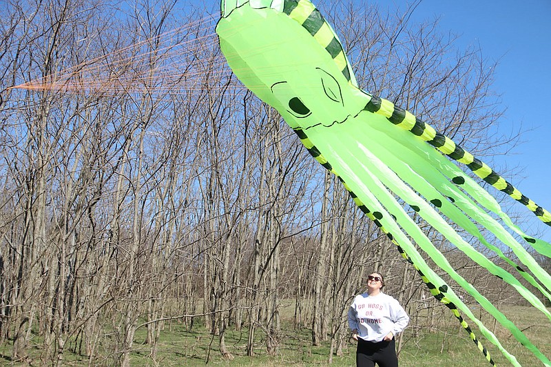 Lynn Kutter/Enterprise-Leader
Jessica Rogers of Fayetteville watches as her husband's octopus kite takes flight at the Cane Hill Kite Festival on Saturday. People of all ages participated in the kite festival at Springfield Ranch in Cane Hill. Wind was almost non-existent, contrary to many other recent days in Northwest Arkansas, but people were able to get the kites up with a lot of running and work. More than 680 came out for the kite festival to enjoy a sunny, warm spring-like day.