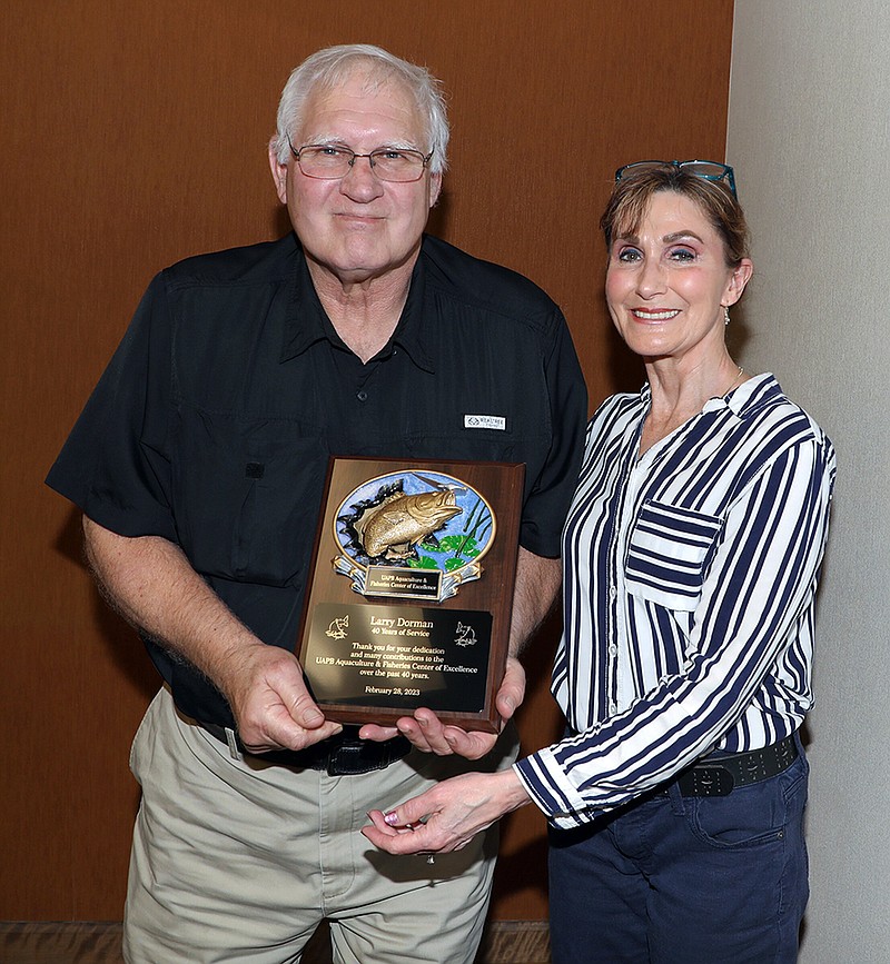 Larry Dorman (left) receives a plaque from Rebecca Lochmann, chair of the University of Arkansas at Pine Bluff Department of Aquaculture/Fisheries, who is on sabbatical. The plaque commemorated Dorman's years of service at UAPB. (Special to The Commercial/University of Arkansas at Pine Bluff)