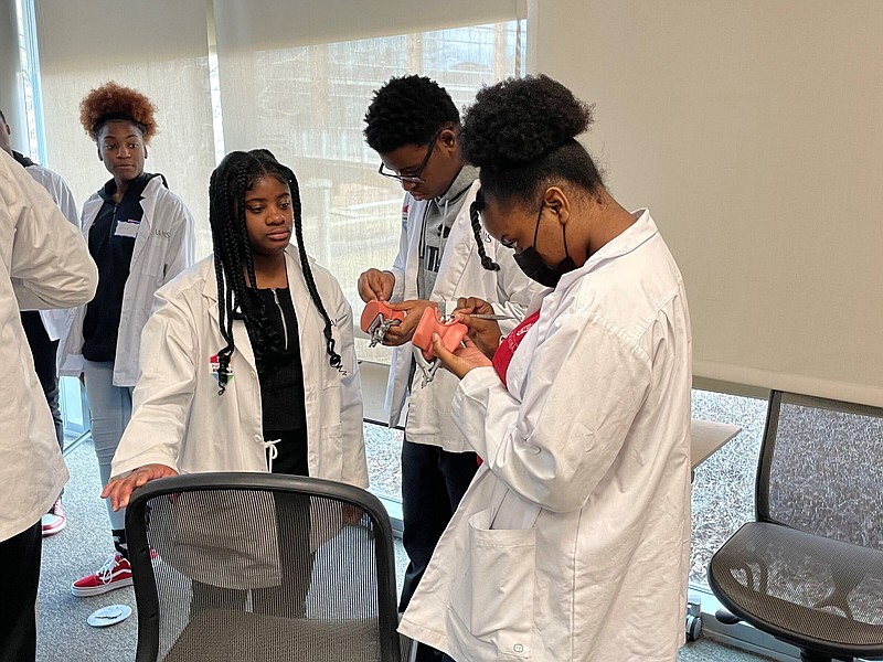 Students use dental molds to learn about the proper technique for handling plaque-removal tools Feb. 18 during the Pathways Academy College of Health Professions Day at the University of Arkansas for Medical Sciences at Little Rock. (Special to The Commercial/Chris Carmody/University of Arkansas for Medical Sciences)