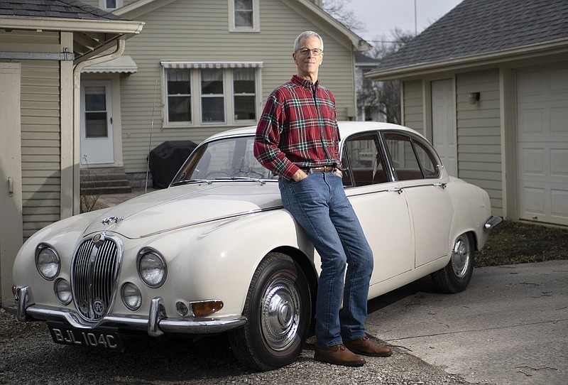 Bill Watkins poses for a portrait with his 1965 Jaguar 3.8 S, Friday, February 10, 2023 at his home in Rogers. Watkins is a staple in the planning commission, always a go-to representative for new building projects in  the Rogers and Lowell areas. Visit nwaonline.com/photos for today's photo gallery.

(NWA Democrat-Gazette/Charlie Kaijo)