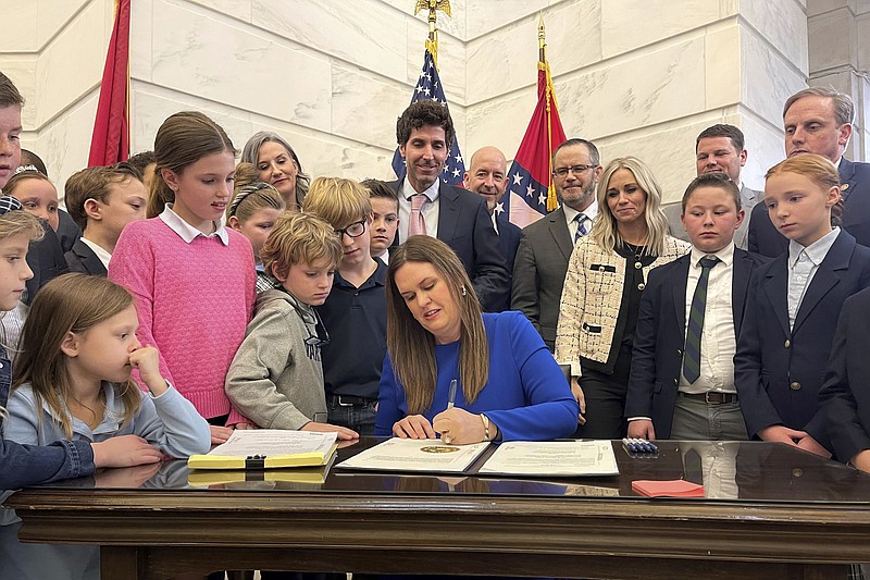 Arkansas Gov. Sarah Huckabee Sanders signs into law an education overhaul bill on Wednesday, March 8, 2023 at the state Capitol in Little Rock, Ark. The legislation creates a new school voucher program that will use public money to help pay for private and home schooling. It also raises teacher salaries and puts new restrictions on classroom instruction on gender identity and sexual orientation.  (AP Photo/Andrew DeMillo)