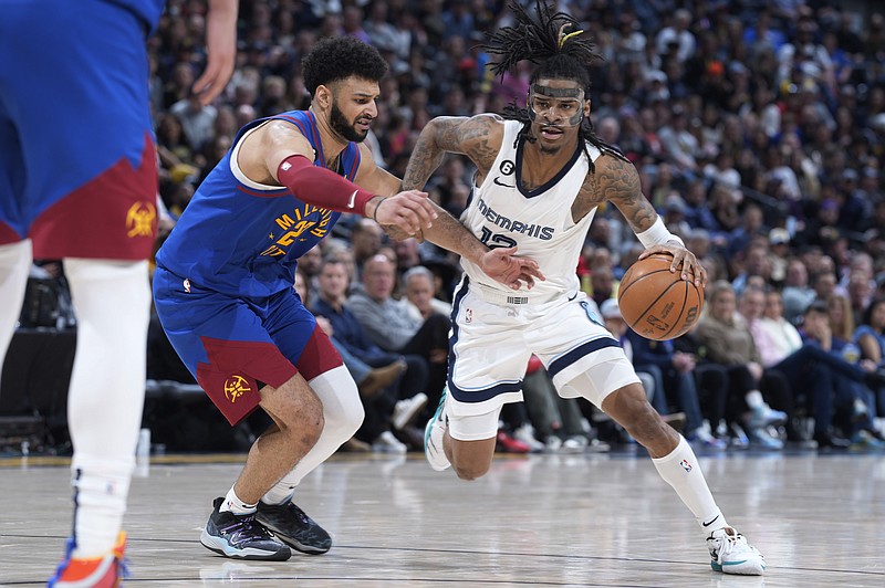 Memphis Grizzlies guard Ja Morant, right, drives against Denver Nuggets guard Jamal Murray during the second half of an NBA basketball game Friday, March 3, 2023, in Denver. (AP Photo/David Zalubowski)