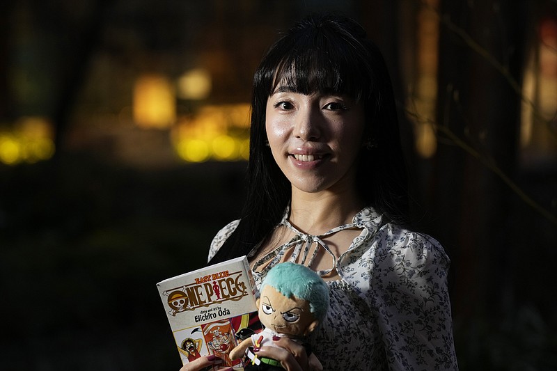 Nina Oiki, a gender and politics researcher at Tokyo’s Waseda University, poses for a photo with some of her favorite “One Piece” anime goods in Tokyo. Hit Japanese manga “One Piece” is coming to Netflix as a live-action series. (The Associated Press/Hiro Komae)
