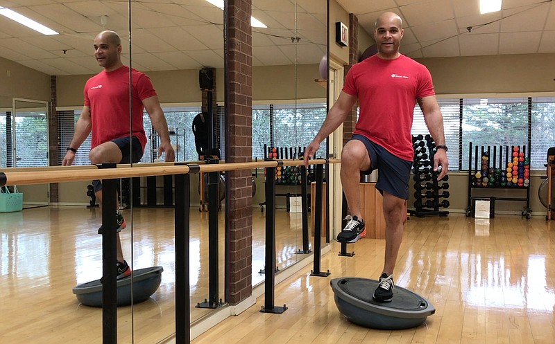 CrossFit trainer Nick Stewart demonstrates the Single Leg BOSU Balance in a studio at Little Rock Racquet Club, for Matt Parrott's Master Class. (Arkansas Democrat-Gazette/Celia Storey)