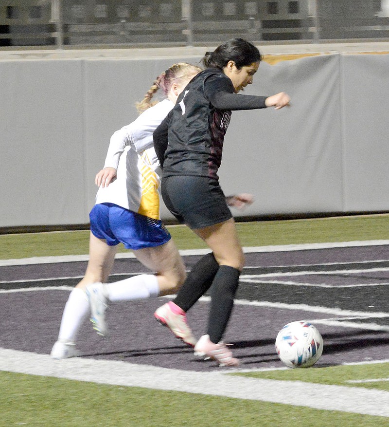Graham Thomas/Herald-Leader
Siloam Springs forward Abby Ballesteros fights off a Mountain Home defender near the Lady Bombers goal for possession during the first half of Friday's game at Panther Stadium.