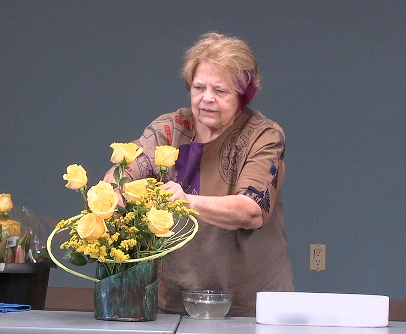 Patricia O'Reilly demonstrates ikebana, or the Japanese art of flower arranging, to attendees of the workshop from the Garland County Library. –Photo by Courtney Edwards of The Sentinel-Record