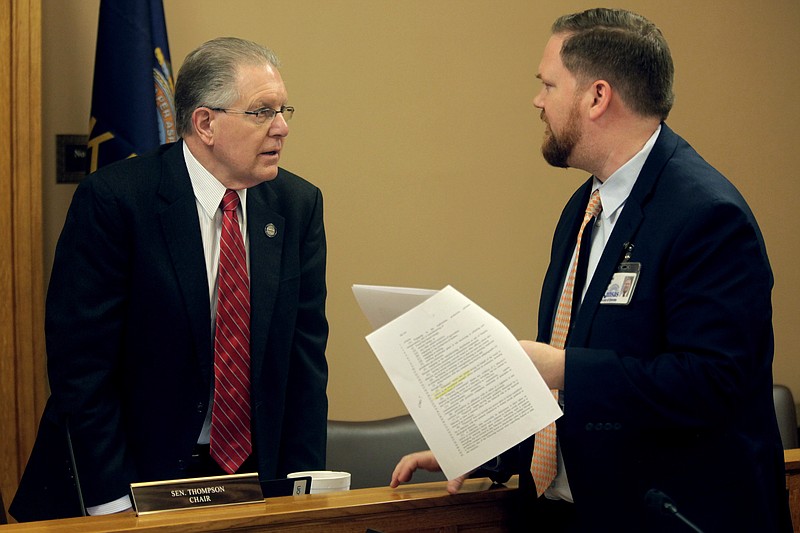 Kansas state Sen. Mike Thompson, R-Shawnee, confers with Jason Long, an attorney on the Kansas Legislature's bill drafting staff before a meeting of the Senate committee Thompson chairs, Tuesday, March 7, 2023, at the Statehouse in Topeka, Kan. Thompson is leading an effort to prevent the state from investing its funds using environmental, social or governance principles. (AP Photo/John Hanna)