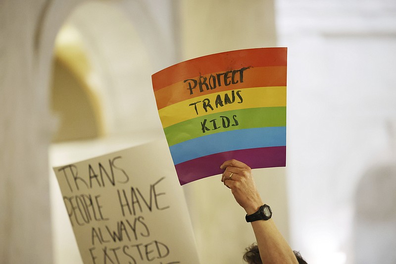 Protestors hold signs during a rally opposing HB2007 at the state capitol in Charleston, W.Va., on March 9, 2023. HB2007 would ban health care for trans children in the state. (AP Photo/Chris Jackson)