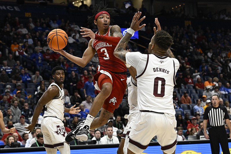 Arkansas guard Nick Smith Jr. (3) looks to pass as Texas A&M guard Dexter Dennis (0) defends during the first half in the quarterfinals of the Southeastern Conference Tournament Friday in Nashville, Tenn. - Photo by John Amis of The Associated Press