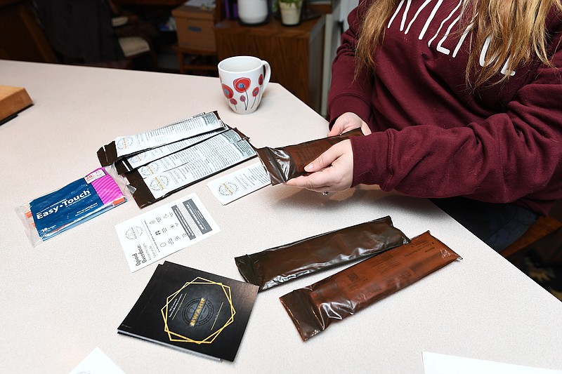 Brittany Kelly assembles opioid overdose rescue kits Thursday, Dec. 22, 2022, at mother Carrie Warren’s house in Fayetteville.  (NWA Democrat-Gazette/Andy Shupe)